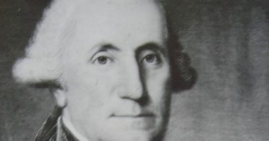 На данашњи дан: Црно-бели портрет мушкарца са белом, коврџавом косом, у капуту са високом крагном и кравати, који гледа директно у посматрача на обичној, тамној позадини.