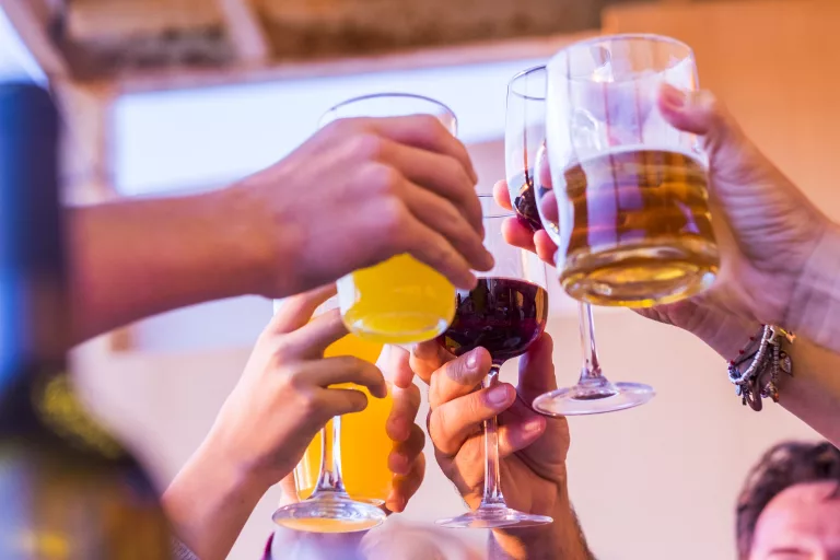 clinking-glasses-above-dinner-table-hands-of-peop-2023-11-27-05-09-21-utc-768x512